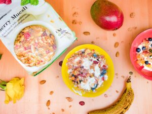 Colorful bowls of creamy muesli and fresh fruits on a wooden table, perfect for a healthy breakfast.