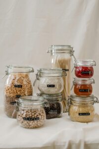 Stylish glass jars for zero waste kitchen storage, featuring grains and dried goods.